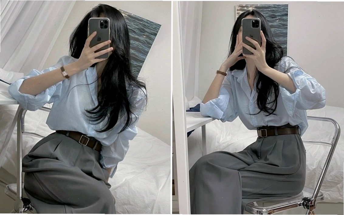 Cô gái tạo dáng quyến rũ trước gương với điện thoại che mặt